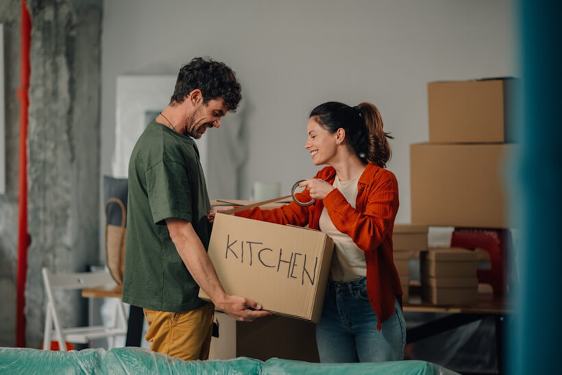 Couple unpacking boxes in a new apartment, related to renters insurance and protection for personal belongings during a move.