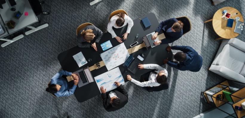 Business team reviewing reports in a meeting, highlighting coverage gaps in business insurance and risk management planning.