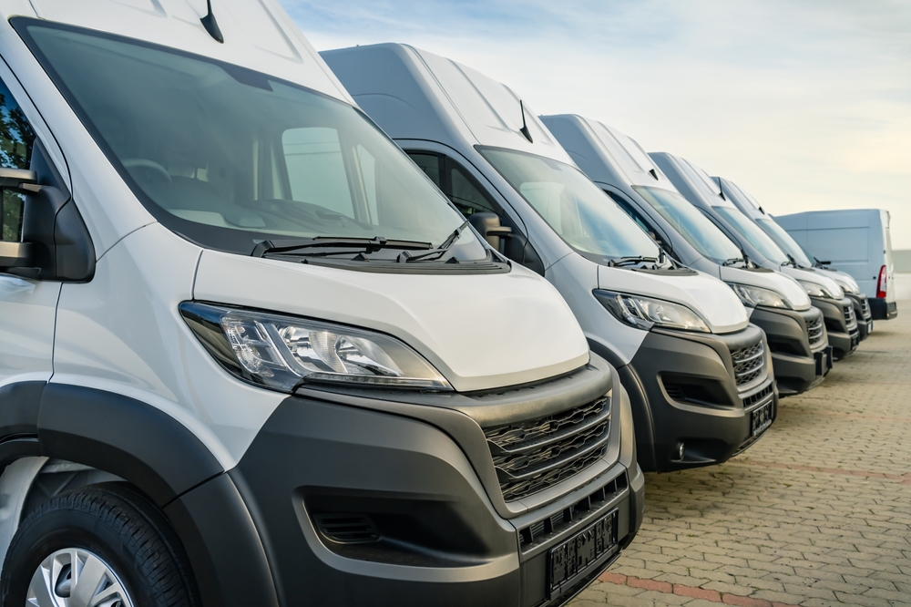 Commercial fleet vans parked in a row, illustrating coverage gaps in business insurance for company vehicles.
