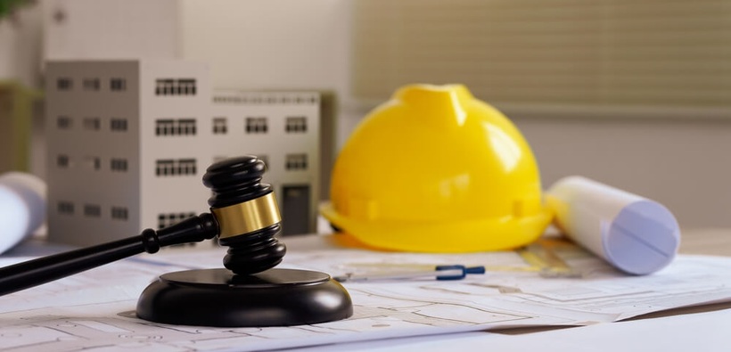 Mazo judicial, casco de construcción y planos que representan ordinance and law coverage.