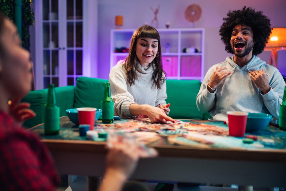 Friends playing a board game together at home, illustrating entertainment liability insurance coverage.