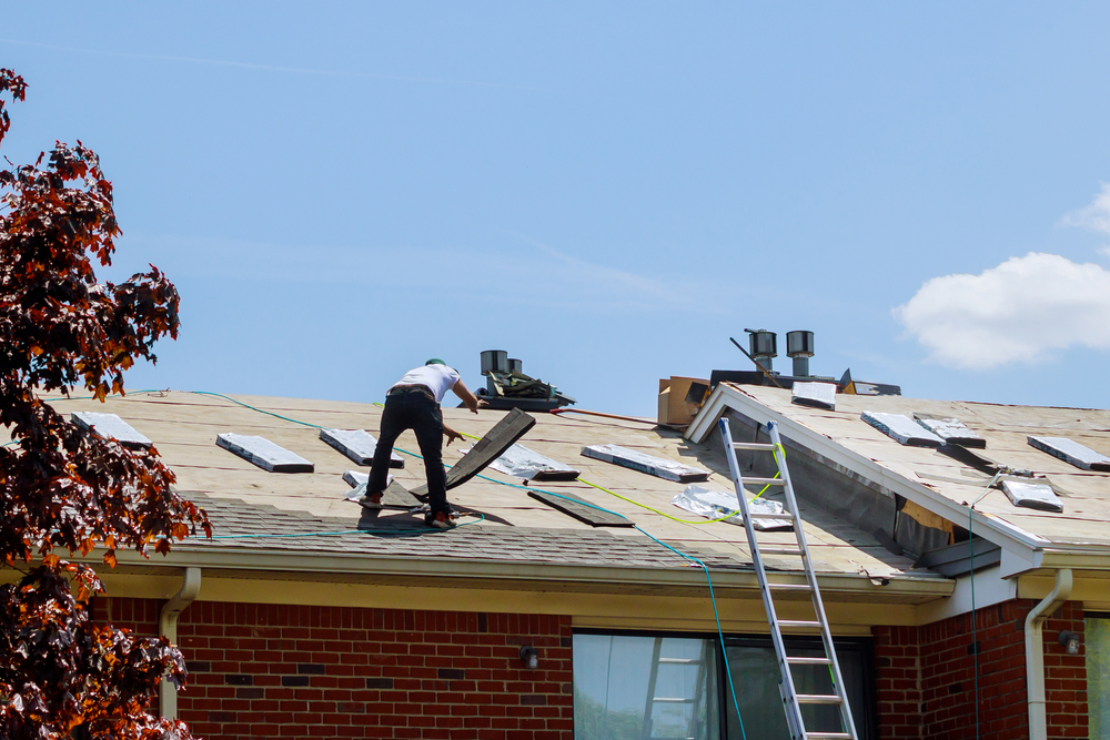 Roofing contractor repairing a home roof, illustrating contractor damage and homeowners insurance coverage.