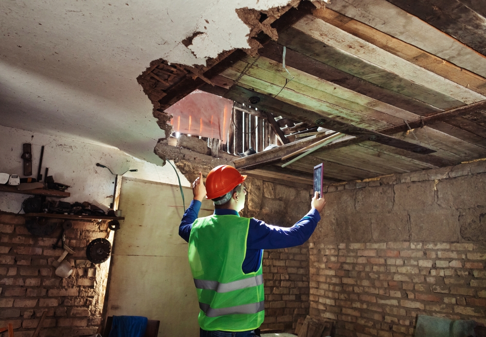 Contractor inspecting damage to a home’s ceiling, illustrating contractor damage and homeowners insurance coverage.