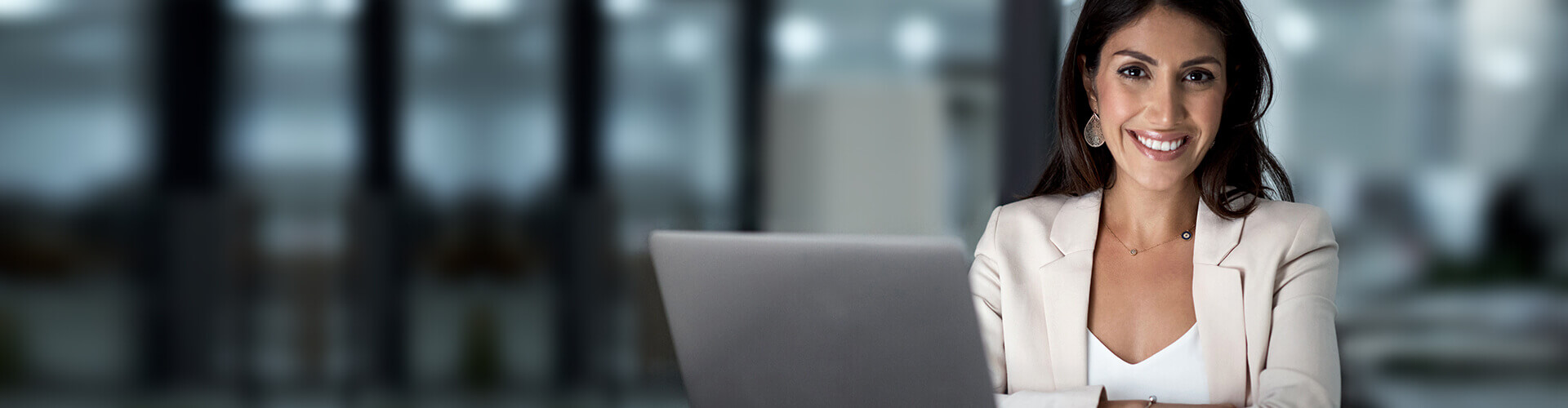 Smiling professional woman in an office with a latop