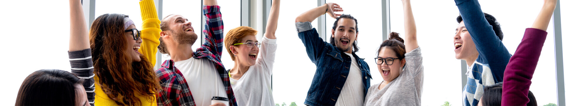 Group of happy people celebrating with their arms up