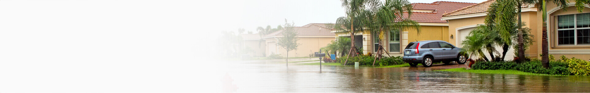 Side view if home and car on a flooded street