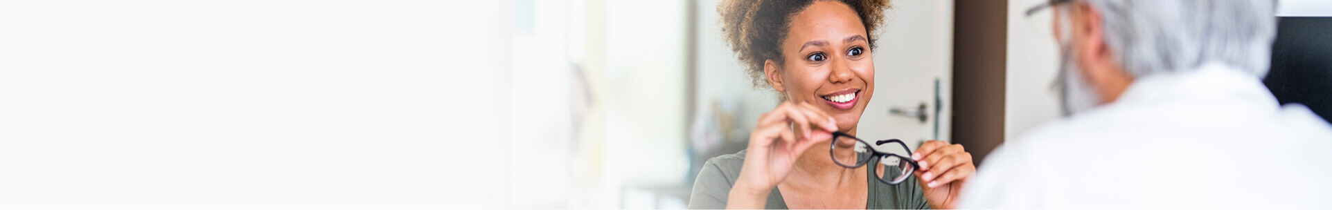 Woman picking new eyeglasses with doctor
