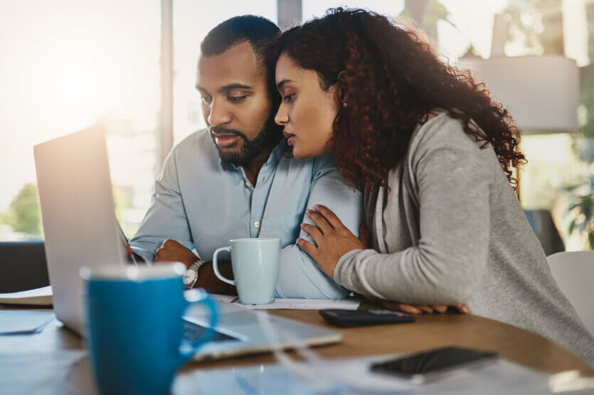 Young couple looking at life insurance options in laptop