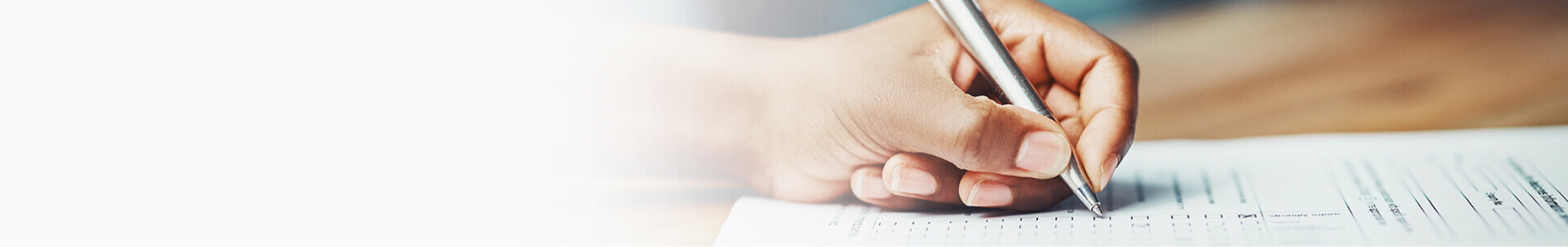Hand with pen signing a paper with a life insurance policy