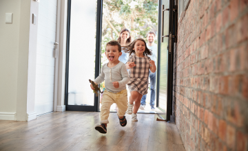 Excited Children Arriving Home With Parents.