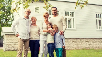 Multi-generational family standing in front of home.