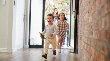 Excited Children Arriving Home With Parents.