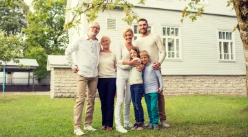 Multi-generational family standing in front of home.