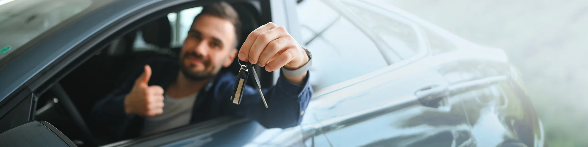Young man is choosing a new vehicle in car dealership.