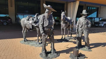 Statues at the Laredo Airport featuring a Mexican vaquero (Spanish for Cowboy) meeting an American cowboy, accompanied with their horses – best home insurance in Texas.