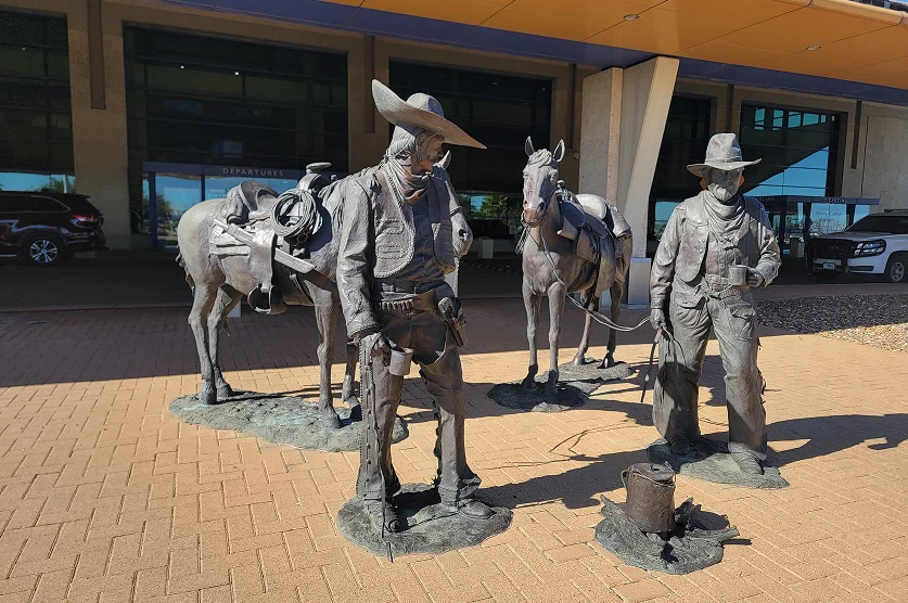 Statues at the Laredo Airport featuring a Mexican vaquero (Spanish for Cowboy) meeting an American cowboy, accompanied with their horses – best home insurance in Texas.