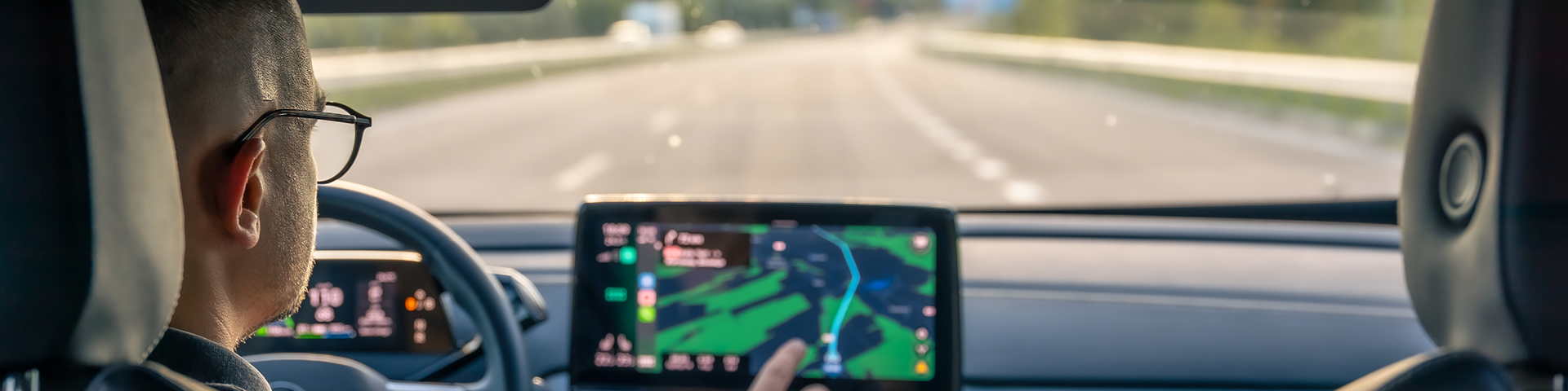 Man touching screen of a GPS navigation system in his car.