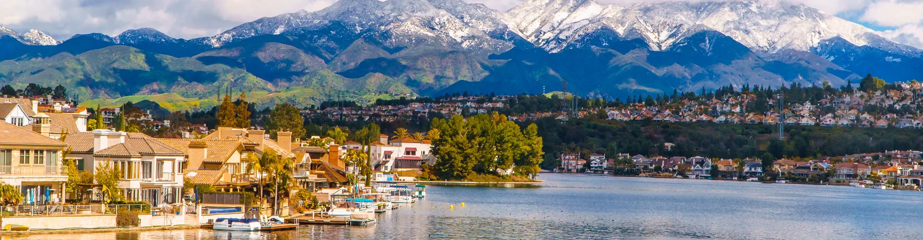 Scenic Lake Mission Viejo with snow capped Santa Ana Mountains in the distance, after epic snowstorm in Southern California - Best car insurance in California.