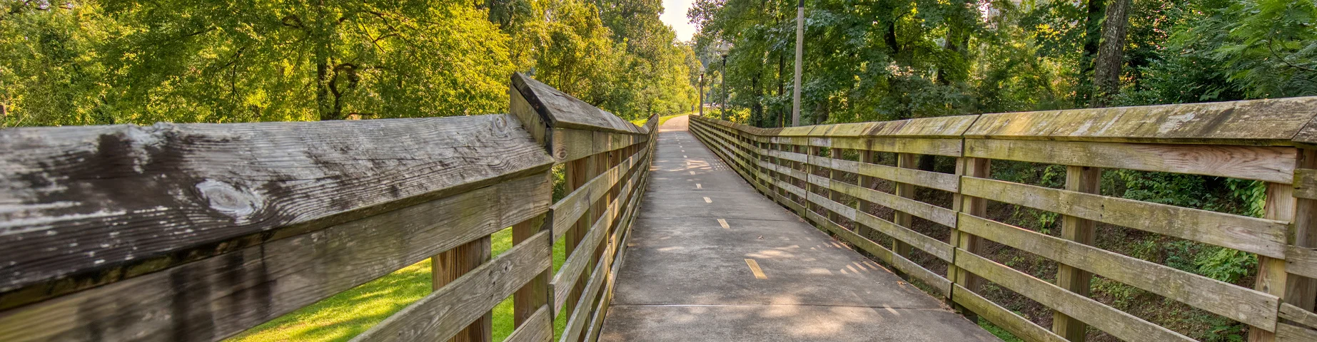 Walking and biking trail with wooden railings along the riverfront in Tuscaloosa - best home insurance in Alabama.