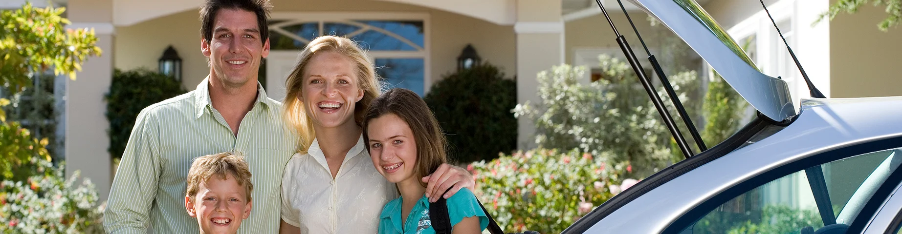 Family Outside New Home On Moving Day Loading Or Unloading Boxes From Car, bundling car and home insurance for savings.