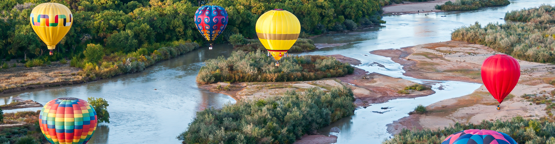 Hot Air Balloons flying over the Rio Grande River – best car insurance in New Mexico.