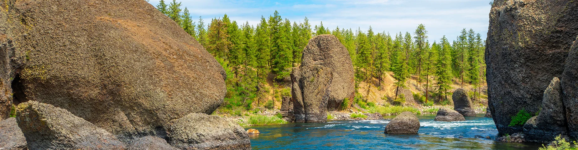 Large boulders and river rapids long the Spokane River at the Bowl and Pitcher area of Riverside State Park in Spokane - best car insurance in Florida.