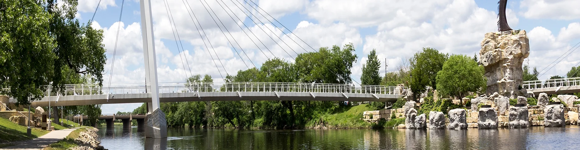 This is a photo of the Keeper Of The Plains statue and foot bridge across the Arkansas River near downtown in Wichita, Kansas.