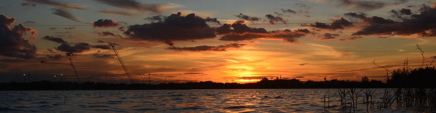 Golden sunset reflecting on the calm lake waters at Amelia Earhart Park in Hialeah, Miami, Florida