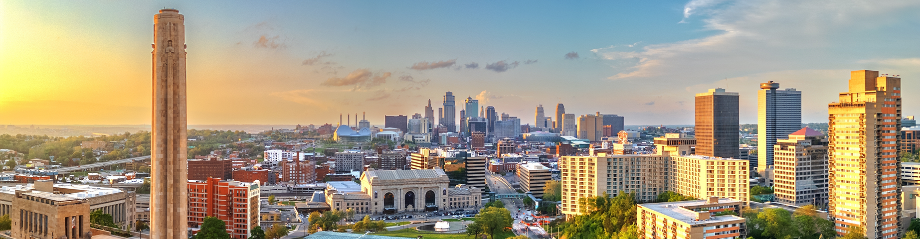 Kansas City skyline at sunset with the Liberty Memorial in the foreground, representing Kansas car insurance coverage in an urban setting.
