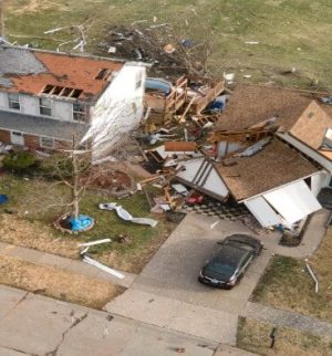 Aerial view of tornado-damaged homes and debris in a residential neighborhood, illustrating tornado home insurance claims and storm damage coverage.