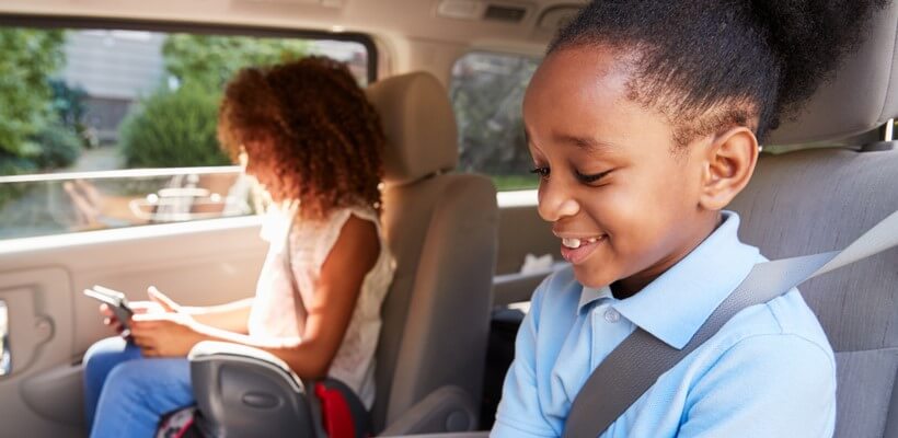 two african american girls in cars with booster seats
