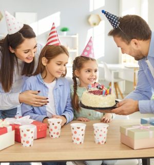 Happy family celebrating their young daughters birthday. They have umbrella insurance to ensure peace of mind.
