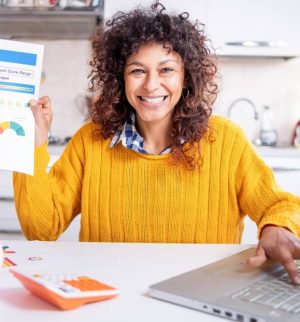 Happy woman checking her good credit score online, improved her credit score by bundling her insurance.