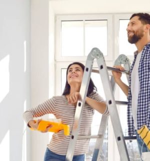 Couple painting and renovating their home, highlighting the importance of a home improvements insurance review before starting projects.