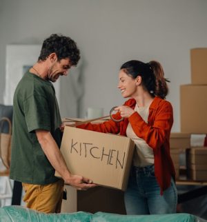 Couple unpacking boxes in a new apartment, related to renters insurance and protection for personal belongings during a move.