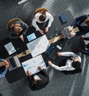 Business team reviewing reports in a meeting, highlighting coverage gaps in business insurance and risk management planning.