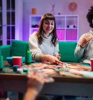 Friends playing a board game together at home, illustrating entertainment liability insurance coverage.