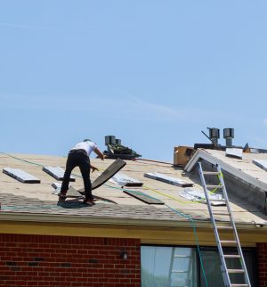 Roofing contractor repairing a home roof, illustrating contractor damage and homeowners insurance coverage.